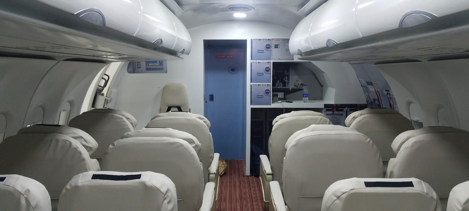 Forward cabin with cockpit door and overhead bins